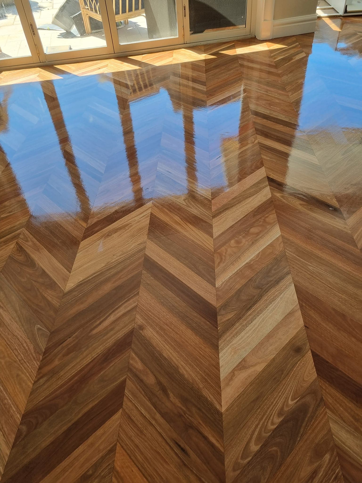 Glossy herringbone parquetry floor sanded and polished in a Sydney home