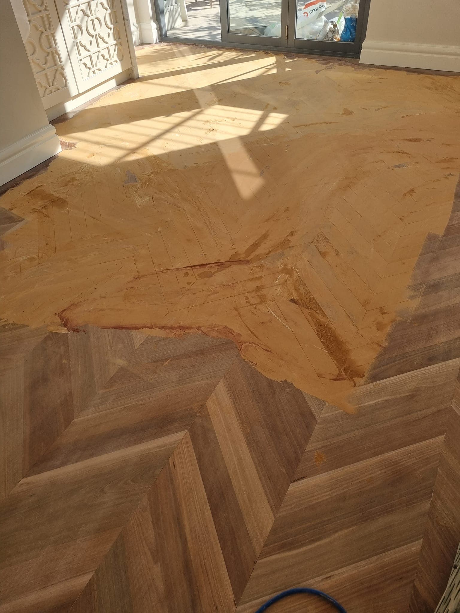 Sydney herringbone parquetry floor mid-restoration with filler applied